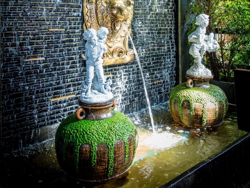 Indoor Fountain in Front of Ornate Windows